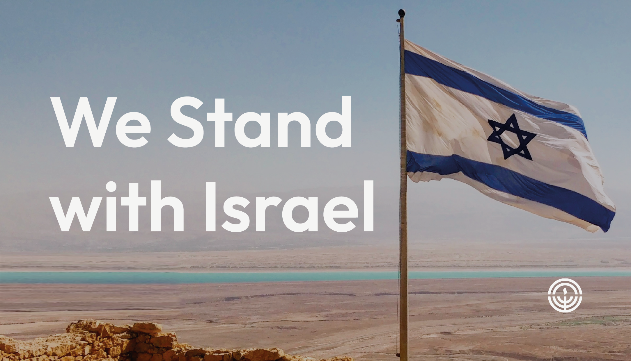 Flag of Israel flying on a flag pole at a military post with text the reads Stand by Israel
